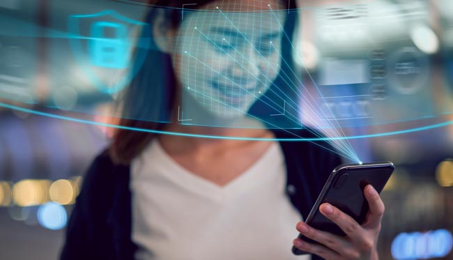 Entsperrcode: Frau hält sich für Face ID das Handy vors Gesicht. Bild: stock.adobe.com/sitthiphong (https://stock.adobe.com/de/images/face-identification-technology-concept-asian-woman-holding-smartphone-and-scanning-face-id-recognition-system/294441757?asset_id=294441757)