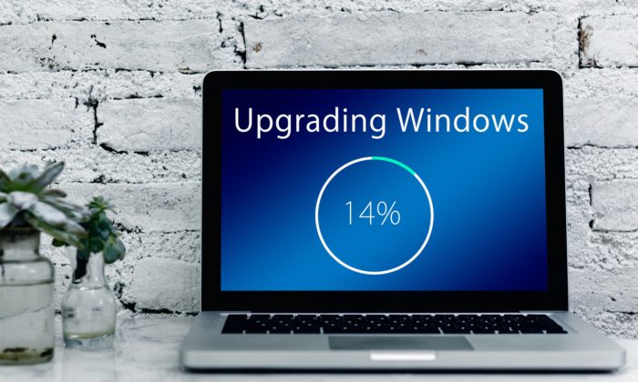 Zu sehen ist ein Laptop auf einem Tisch direkt vor einer Wand. Upgrading Windows ist gerade im Prozess, ein neues Betriebssystem wird aufgespielt. Bild: www.pixabay.com / Gerd Altmann