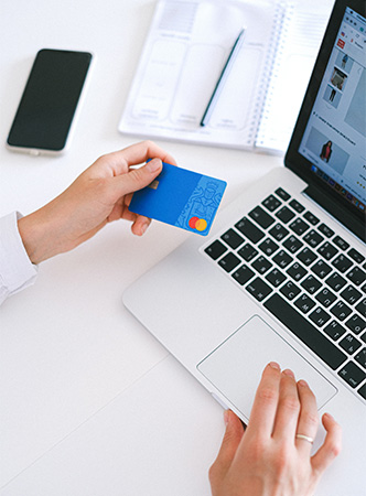 Xenomorph: Person mit EC-Karte am Laptop, Handy liegt daneben. Bild: Pexels/Anna Shvets