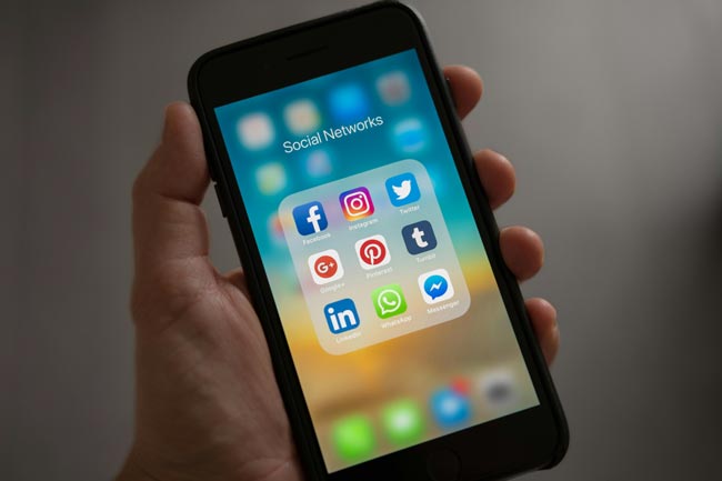 Handy zeigt Ordner mit Apps rund um die sozialen Medien. Bild: Pexels/Tracy Le Blanc (https://www.pexels.com/de-de/foto/person-mit-iphone-die-den-ordner-fur-soziale-netzwerke-anzeigt-607812/)