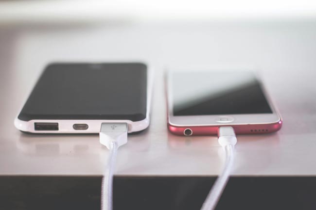 Zwei Handys, verbunden mit Kabel. Bild: Pexels/Steve Johnson (https://www.pexels.com/de-de/foto/geschlossene-fotografie-von-zwei-iphones-1028674/)