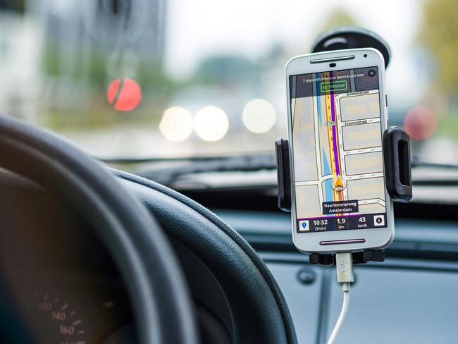 Weißes Smartphone in Hlaterung an Windschutzscheibe zeigt dem Fahrer die Route an. Pexels/Pixabay (https://www.pexels.com/de-de/foto/weisses-android-smartphone-im-fahrzeug-33488/)