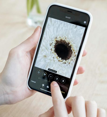 kostenloses Bildprogramm: weißes iPhone mit Blumenbild im Bearbeitungsmodus. Bild: Pexels/Anna Nekrashevich (https://www.pexels.com/de-de/foto/hande-fotograf-technologie-bild-7550898/)