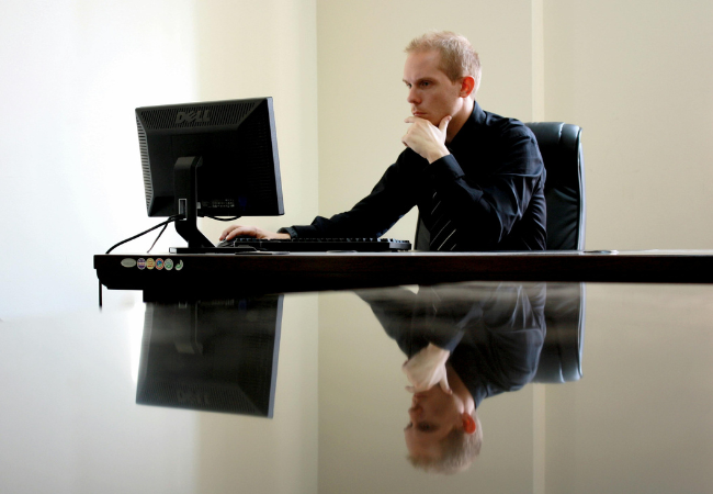 Laptop-Bildschirm schwarz I Ein Mann mit schwarzem Hemd sitzt vor einem Laptop. Bild: Pexels/ David McEachanhttps://www.pexels.com/de-de/foto/mann-sitzt-gegenuber-pc-im-zimmer-90333/