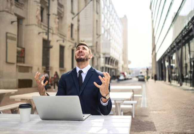 Laptop-Bildschirm schwarz I Ein Mann sitzt draußen in der Stadt vor seinem Laptop und verzweifelt. Bild: Pexels/ Andrea Piacquadio