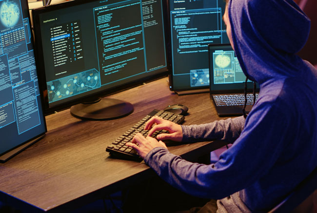 Microsoft-Defender-Sicherheitslücke: Hacker an mehreren Monitoren. Bild: stock.adobe.com/DC Studio https://stock.adobe.com/de/images/hackers-brainstorming-methods-of-breaching-defenses-and-exploiting-weaknesses-in-computer-systems-evil-developers-in-basement-getting-past-companies-security-networks/716031490
