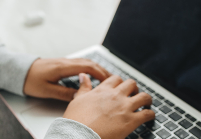 Downtime im Unternehmen: Hände tippen auf einem Laptop, Bild: Pexels/ Polina Tankilevitchhttps://www.pexels.com/de-de/foto/hande-laptop-tippen-verbindung-7382386/